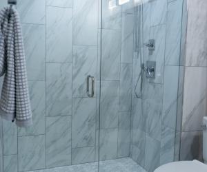 custom tiled shower in white granite, floor to ceiling glass, Parker, CO 2021